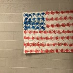 American flag made out of hand prints hanging in hallway