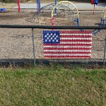 American Flag made of Dixie Cups in the fence