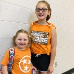 Two students wearing college team colors