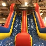 students going down slide on bounce house